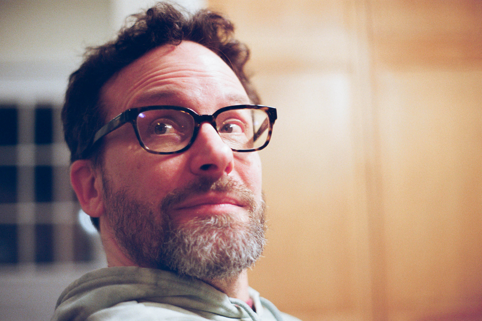 A photo of John Booth, a white male with dark brown hair, brown, eyes, a pepper beard and tortoiseshell glasses.